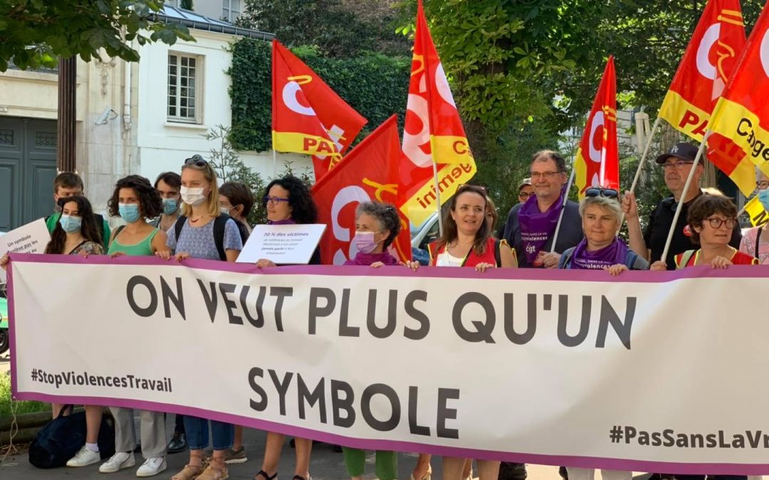 des militant.es de la CGTavec drapeuax et pancartes revendicatives sur les violences et d'associations Action aid et Care derrière une banderole "On veut plus qu'un symbole" #stopviolencestravail #passanslavraie190 devant l'assemblée nationale qui votait le lendemain la ratification de la concvention contre le harcèlement et la violence dans le monde du travail